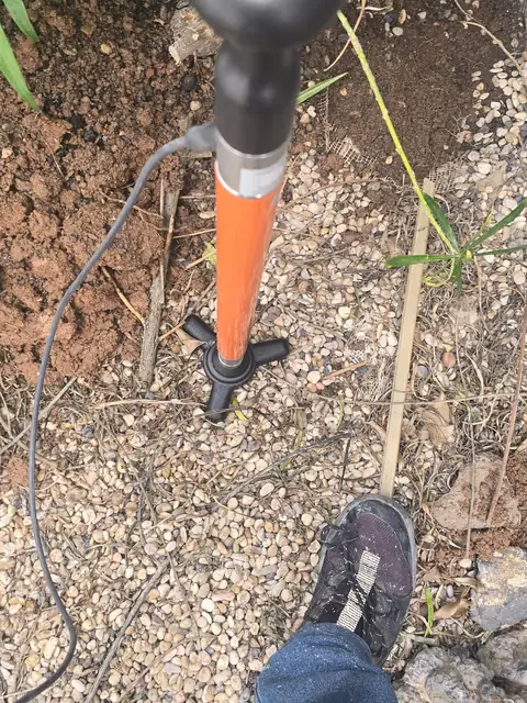 Geófono escuchando una fuga de agua enterrada en un jardín